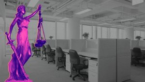 An black and white row of empty desks in an office, a brightly colored lady justice statue enters from the left.